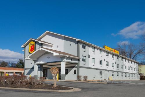 a white building with a sign on the side of it at Super 8 by Wyndham Charlottesville in Charlottesville