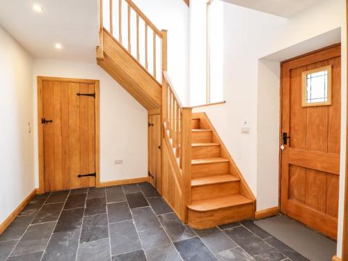 a staircase in a house with a wooden door at Cwmwr in Pen-y-bont-fawr