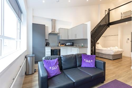 a living room with a couch with purple pillows at Pillo Rooms Serviced Apartments - Manchester Arena in Manchester