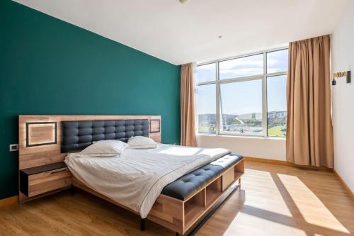 une chambre avec un grand lit avec un mur bleu dans l'établissement Luxury Apartment Hilton 5*, à Tanger