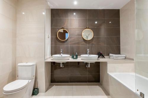 La salle de bains est pourvue de toilettes, de 2 lavabos et d'une baignoire. dans l'établissement Luxury Apartment Hilton 5*, à Tanger