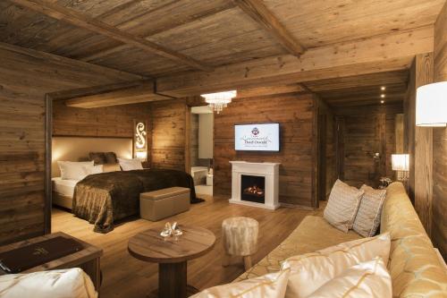 a bedroom with a bed and a fireplace at Wellnesshotel Oswald in Kaikenried