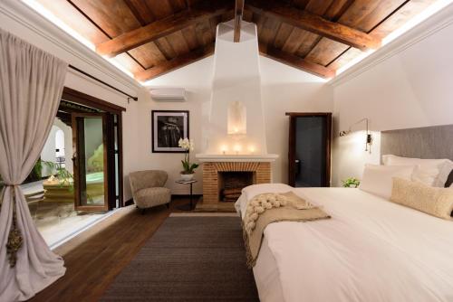 um quarto com uma cama grande e uma lareira em Villa Las Mil Flores em Antigua Guatemala