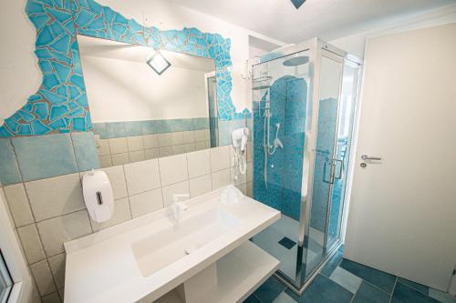 ein Bad mit einem Waschbecken und einer Dusche in der Unterkunft Villa la Torre Libeccio in Torre Dei Corsari