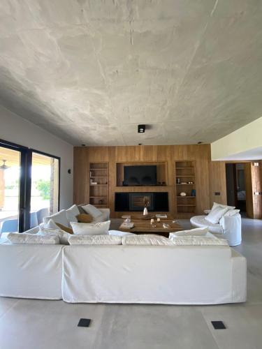 una sala de estar con un gran sofá blanco y sillas en Casa Pueblo Estancia La Paz en Jesús María