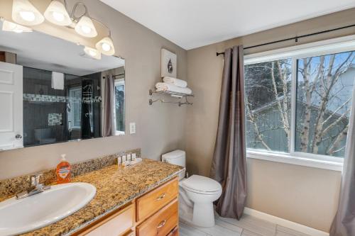 a bathroom with a sink and a toilet and a window at Once Upon a Tide in Lincoln City