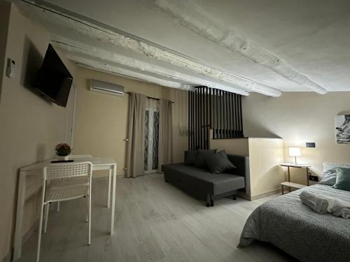 a living room with a bed and a table and a couch at Olinad rooms in Castelbuono