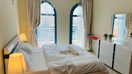 1 dormitorio con 1 cama blanca y 2 ventanas en Newly furnished cozy ONE bed room Apartment 2 bathroom city view, en Dubái