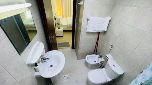 y baño con lavabo, aseo y espejo. en Newly furnished cozy ONE bed room Apartment 2 bathroom city view, en Dubái