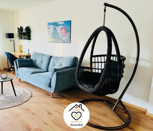 a swing in a living room with a blue couch at Family M Apartments 4-5-6 in Kappel bei Olten