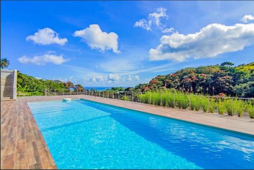 a swimming pool with a view of the ocean at Condo Airport Tahiti Faa'a in Faaa