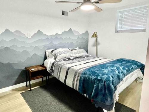 een slaapkamer met een bed met een muurschildering van de bergen bij Updated Mountain Cabin Retreat with 180 views off Deck and Balcony in Running Springs