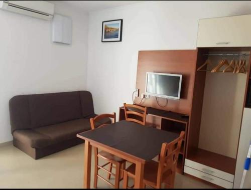 una pequeña sala de estar con mesa y sofá en Apartments Strandburg Kroatien, en Živogošće