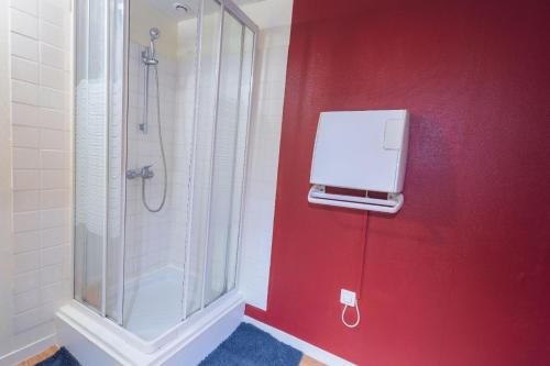 baño con ducha y pared roja en Paris Ain, en Coligny