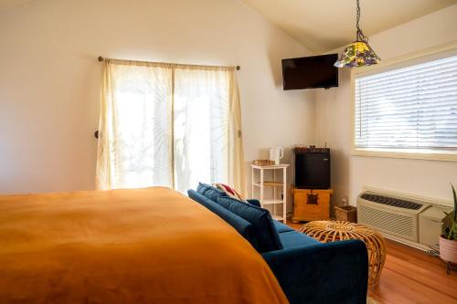 a bedroom with a bed and a couch and a television at The Loubird Inn in Escalante