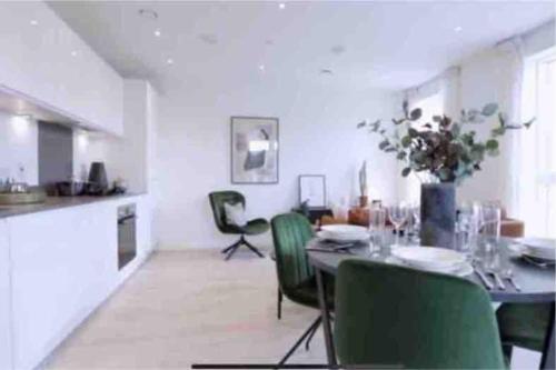 a dining room with a table and green chairs at Luxury 1 bedroom East London in London