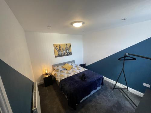 a bedroom with a bed with a blue accent wall at Anfield accomodation in Liverpool