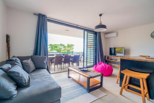 a living room with a couch and a table at Condo Airport Tahiti Faa'a in Faaa