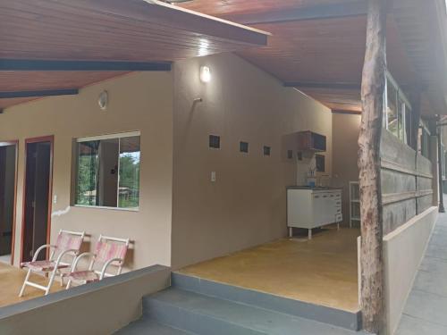 a living room with two chairs and a staircase at Casa Nirvana para Temporadas in Alto Paraíso de Goiás