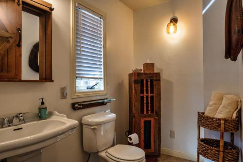 a bathroom with a toilet and a sink and a mirror at The Loubird Inn in Escalante