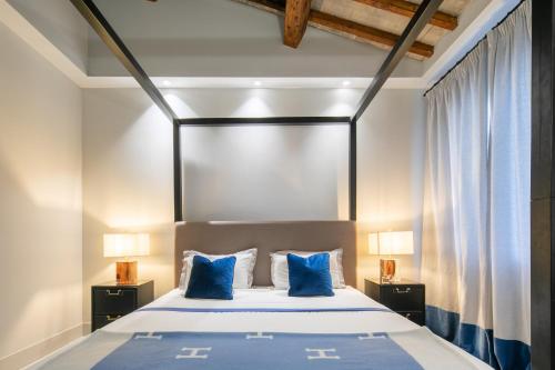 een slaapkamer met een groot bed met blauwe kussens bij Firenze F1 in Florence