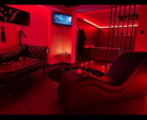 uma sala de estar vermelha com um sofá e uma televisão em Loveroom Metz Spa Privatif em Metz