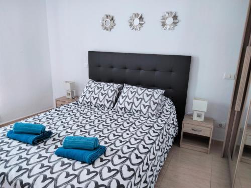 1 dormitorio con cama blanca y negra con almohadas azules en City Centre Arrecife en Arrecife