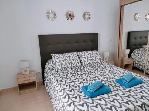 een slaapkamer met een groot bed met blauwe kussens erop bij City Centre Arrecife in Arrecife