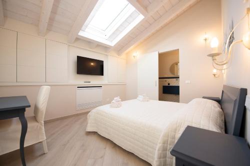 a bedroom with a bed and a desk and a tv at Villino Micol camere a due passi dal mare in Marina di Carrara