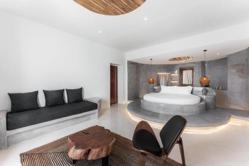een slaapkamer met een bed, een bank en een tafel bij Leon Luxury Suites in Imerovígli
