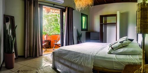 a bedroom with a bed and a sliding glass door at Villa Beijaflor in Santo André