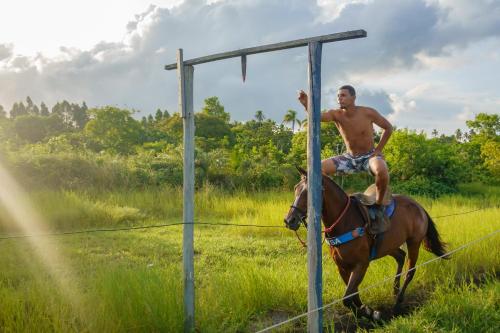 a man riding a horse in a field at Villa Beijaflor in Santo André
