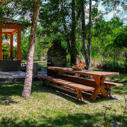 a wooden picnic table in a park with a tree at Villa Beijaflor in Santo André