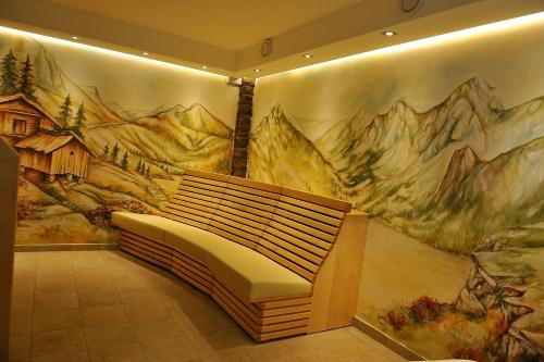 a bench in a room with a painting on the wall at nawu apartments & Restaurant in Hermagor