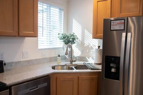 a kitchen with a stainless steel refrigerator and a sink at Modern 2-Bedroom Eucalyptus House in San Luis Obispo