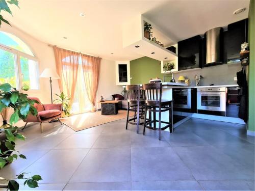 une cuisine et un salon avec une table et des chaises dans l'établissement Climatisé & Cosy - T3 55 m2 parking à 2 mn de Lyon, à Caluire-et-Cuire