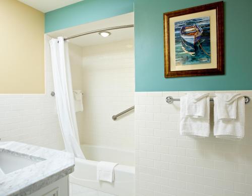 a bathroom with a white tub and a sink at Breezeway Boutique Hotel in Westerly