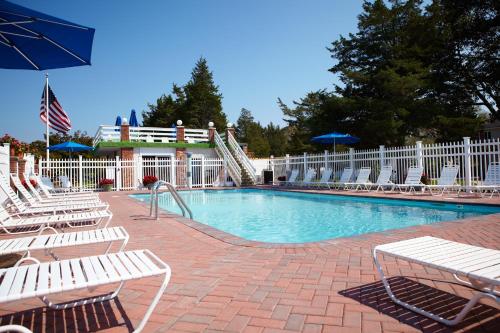 a swimming pool with chairs and an umbrella at Breezeway Boutique Hotel in Westerly