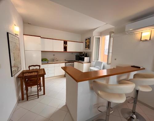 une cuisine avec des armoires blanches et un comptoir en bois dans l'établissement Appartement spacieux en face du port, à Calvi