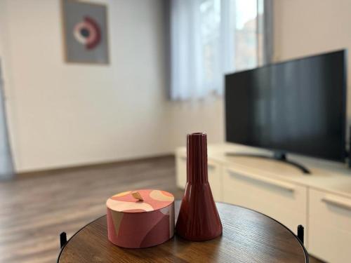 uma mesa com um vaso e uma caixa em Golden Apartment Schwabach em Schwabach