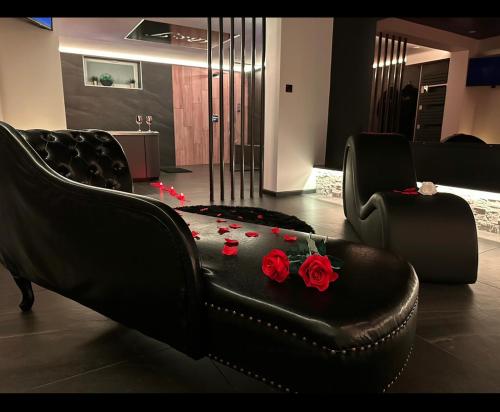 una sala de estar con un sofá con rosas. en Loveroom Metz Spa Privatif, en Metz