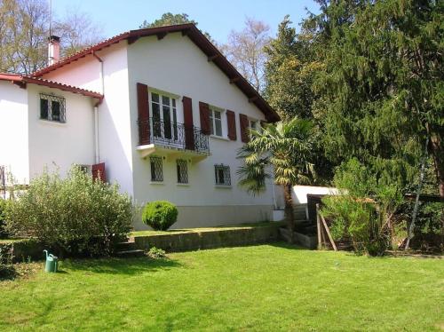 une maison blanche avec une cour devant elle dans l'établissement t3 au rez de jardin d une maison, à Anglet