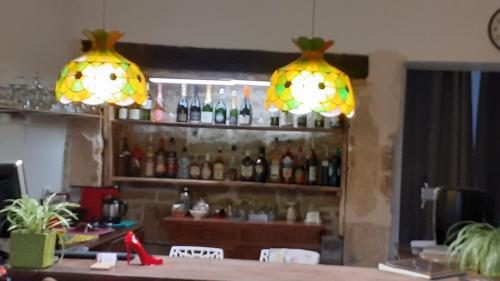 two lights above a bar with bottles of alcohol at Le Domaine d'Élise Chambres et table d'hôtes - Vosges in Saint-Ouen-lès-Parey