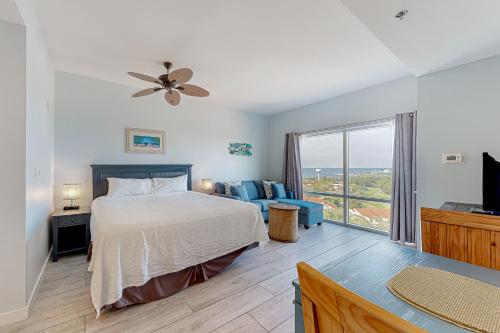 a bedroom with a bed and a couch and a window at Luau Condos V in Destin