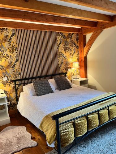 a bedroom with a bed in a room with wallpaper at Chez Jallot - Upper Gite in Vidaillat