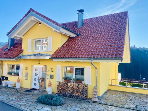 una casa amarilla con techo rojo en Sonnenberg Resort, en Elzach