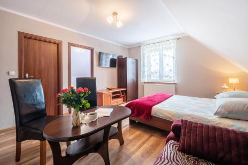 a hotel room with a bed and a table with a table at Agroturystyka Dom Pod Malinami in Domaszków