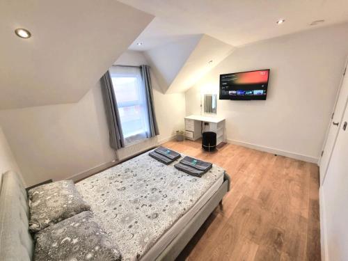 um quarto com um sofá e uma televisão na parede em LMK, 2 Bedroom Apartment, with Roof Terrace, Free parking, EV Charger, Great Location. em Belfast