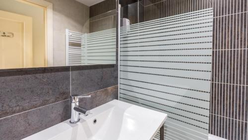 a bathroom with a white sink and a mirror at Pensión 9 de Abril in O Pedrouzo