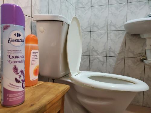 a bathroom with a toilet and a bottle of cleaner at Au cœur de Ouidah in Ouidah